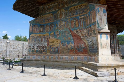 Church façade with impressive frescoes and icons in the open air, exterior view, Saint George