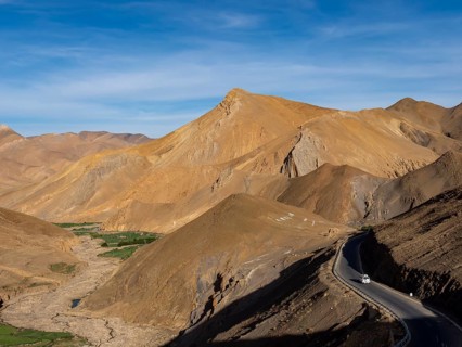 Road along yellow mountains in the highlands of Tibet, China