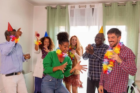 A lively birthday party scene featuring a group of friends dancing and celebrating together. They