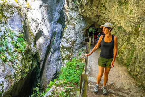 Female tourist exploring tolmin gorge in triglav national park, enjoying breathtaking rock