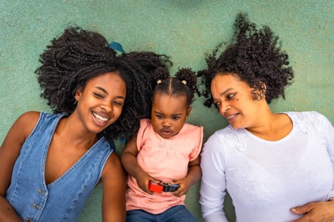 Top view of african happy multi-generational family lying on the ground of a park
