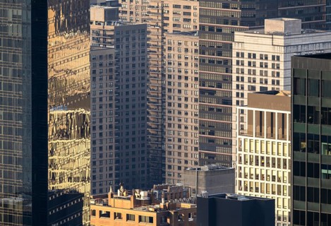 From above, the sunlit facade of New York's high rise buildings and skyscrapers showcases an urban