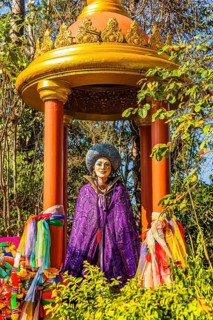 Statue of a woman with purple cape in a gilded pagoda in the Buddhist temple Wat Phra That Don Phra