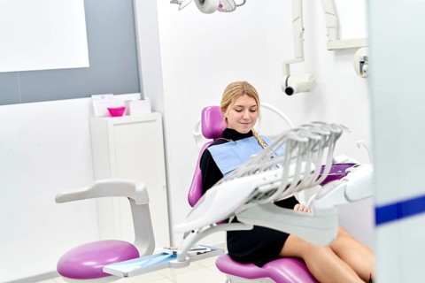 A patient sits comfortably in a modern dental clinic, preparing for a dental examination. The