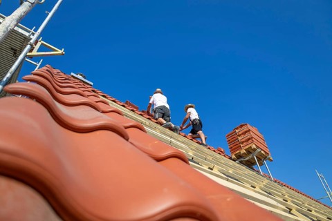 Roofers covering a tiled roof