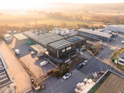 Industrial complex with solar systems on the roofs, surrounded by rural landscape, Bauhof,