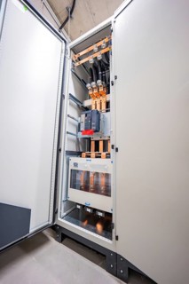 Open control cabinet housing with visible cabling and electronics, electrical system for PV system,