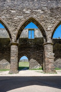 View through a well-preserved, ogival double tracery window of the Gothic monastery ruins of the