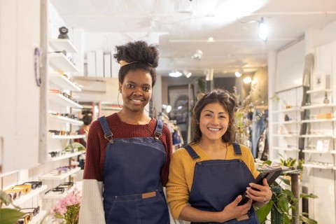 A vibrant sunglasses store showcases its friendly staff ready to assist customers. The bright