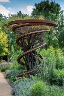Spiral shaped monument, at the same time modern corten steel trellis, lists the names of all