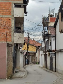 Chaotic installation of power and telecommunications cables on a utility pole, Prizren, Kosovo,