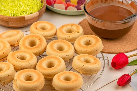 Donuts with chocolate icing to decorate alongside tulips and sweets