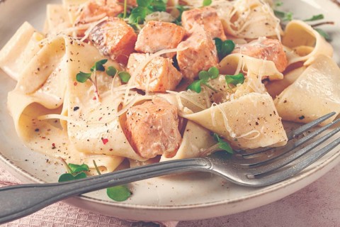 Tagliatelli pasta, with salmon slices and herbs, on a decorative plate, homemade, no people