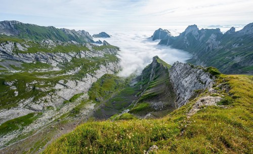 View of mountain peaks above the sea of clouds, Säntis mountains and valley of Meglisalp, high fog,