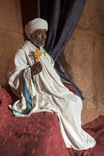 Ethiopian Orthodox priest with a hand cross in the rock church of Biete Gabriel-Rufael Lalibela,