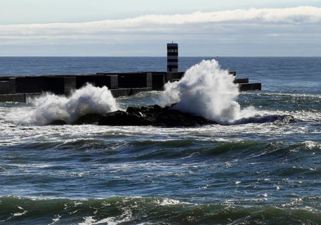 Ocean surf on the Atlantic coast with the Farolim da Barra do Douro lighthouse, Porto, Portugal