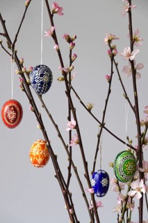 Blooming branches of a peach tree in a vase decorated with Easter eggs, spring, Germany