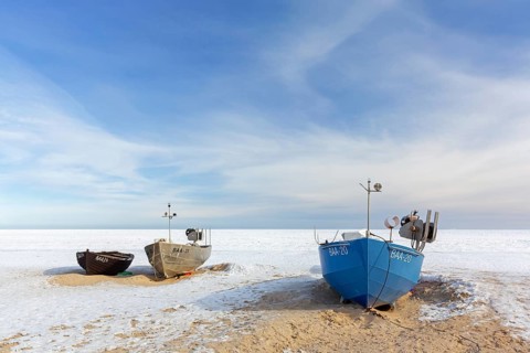 Fishing boats on snow covered beach in winter along the Baltic Sea at Baabe, Mönchgut peninsula,