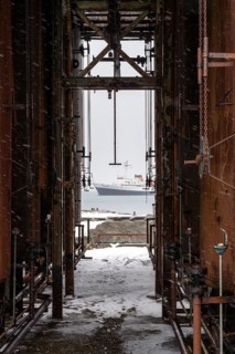 View of the expedition ship Ushuaia in the bay through the rusted industrial plant of the former
