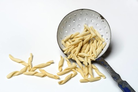 Strozzapreti, uncooked Italian pasta in a sieve, Italy