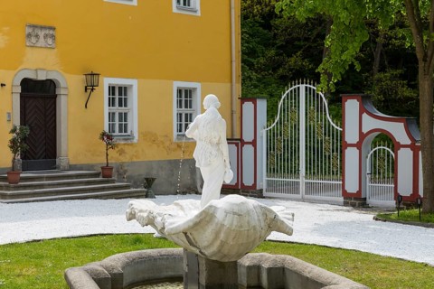 Female figure with water jugs on a shell, white fountain in front of Rauenstein Castle,