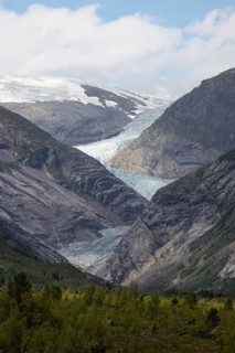 A stunning view of the Nigardsbreen Glacier descending between steep rocky mountains in Norway