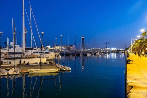 Night shot of the old harbour with boats in Barcelona, Spain