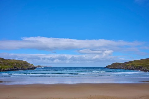A wide, open beach offers views of calm seas and blue skies, Farr Bay, Bettyhill, Thurso, Scotland,