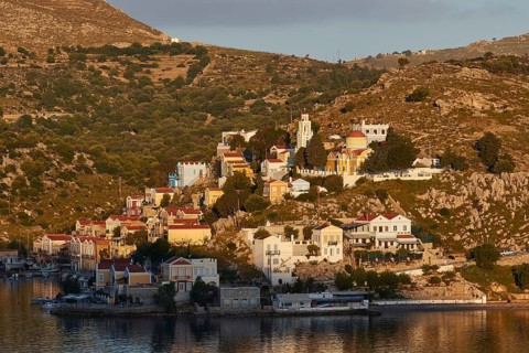 Urban views of a mountain village under warm morning lights with architectural charm, Symi Town,