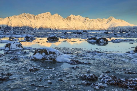 Morning light over snow-covered mountains, fjord, low tide, winter, Lyngen Alps, Norway