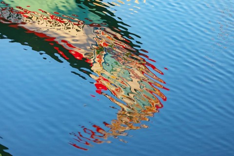 Traditional Moliceiro boat reflected in the water, Aveiro, Portugal