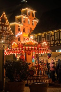 Festively illuminated carousel at a historic Christmas market at night, Christmas market Calw,