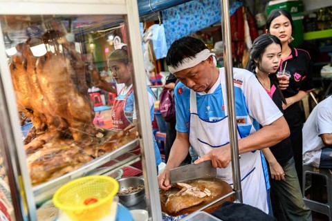 Bangkok, Thailand. February 18th 2025. A local poultry butcher preparing street food at stall in