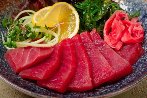 Tuna sashimi with daikon and wakame salad, pickled ginger, in a bowl