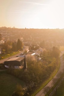 Aerial view of a village in warm afternoon light with roads and trees, Deufringen, Aidlingen,