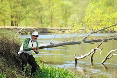 Fisherman trying to do a perfect cast, throwing lure. Spining fishing, angling, catching fish.