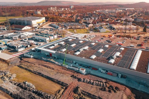 Industrial complex with solar systems and parking spaces in an urban autumn landscape, PV Bau Auf