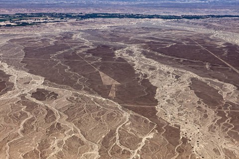 Brown wasteland from the air with impressive line patterns, interrupted by vegetation, the