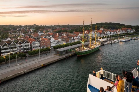 Travellers look from the Finland ferry to the barque Alexander von Humboldt II and the old town of