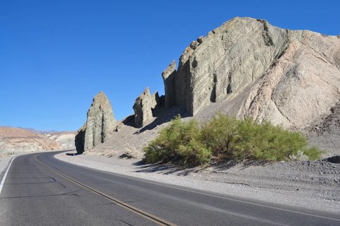 Curvy road through a desert landscape with steep rocks, Death Valley National Park, Mojave Desert,