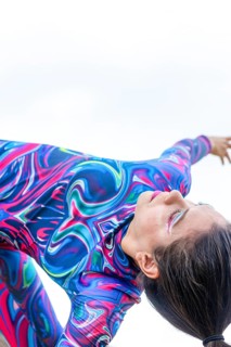 A woman in a colorful outfit passionately dances, embodying the spirit of LGBTQIA+ pride and