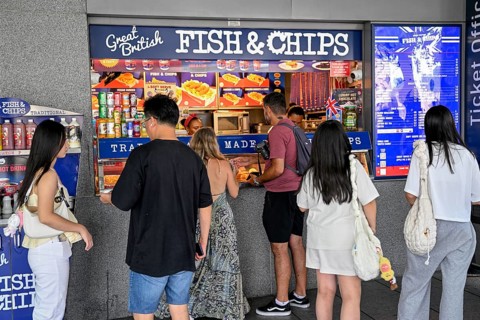 Customers in front of a fish and chip shop at the entrance to the Tower of London, London, England,