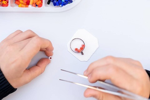 Close-up of hands crafting intricate Murano glass beads, showcasing vibrant colors and delicate