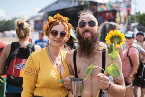 KOSTRZYN NAD ODRA, POLAND - AUGUST 1, 2019: Happy young couple with sunflowers during music