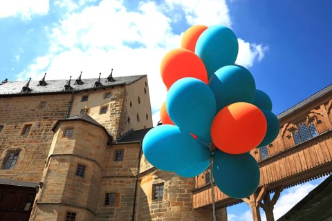 Colourful balloons in front of the transition to the castle seen from the Evangelical Lutheran St.