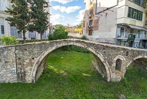 Tanners' Bridge - historic Ottoman-era stone footbridge - surrounded by green grass and city