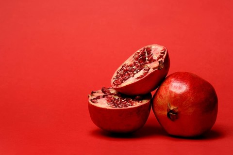 Pomegranate with red background, Punica granatum, cut in half