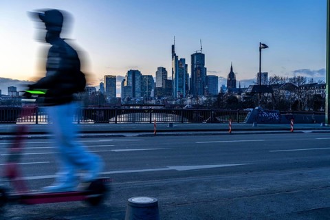 Skyline of the city centre of Frankfurt am Main, e-scooter on the raft bridge, dusk, river Main,