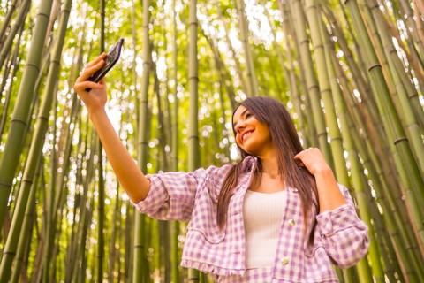 Young caucasian girl with a pink skirt in a bamboo forest. Enjoying summer holidays in a tropical