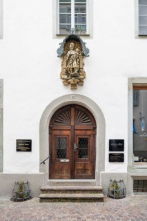 Wooden door with an elaborate sculpture above it at a town house in the historic old town of